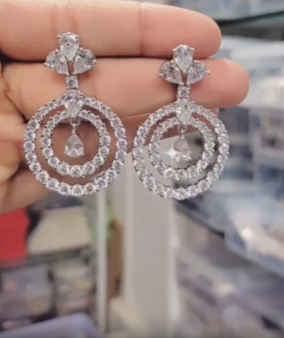A pair of elegant silver American diamond earrings with a chandelier design,